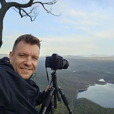 Denis Darkin with camera and tripod overlooking the Blue Mountains