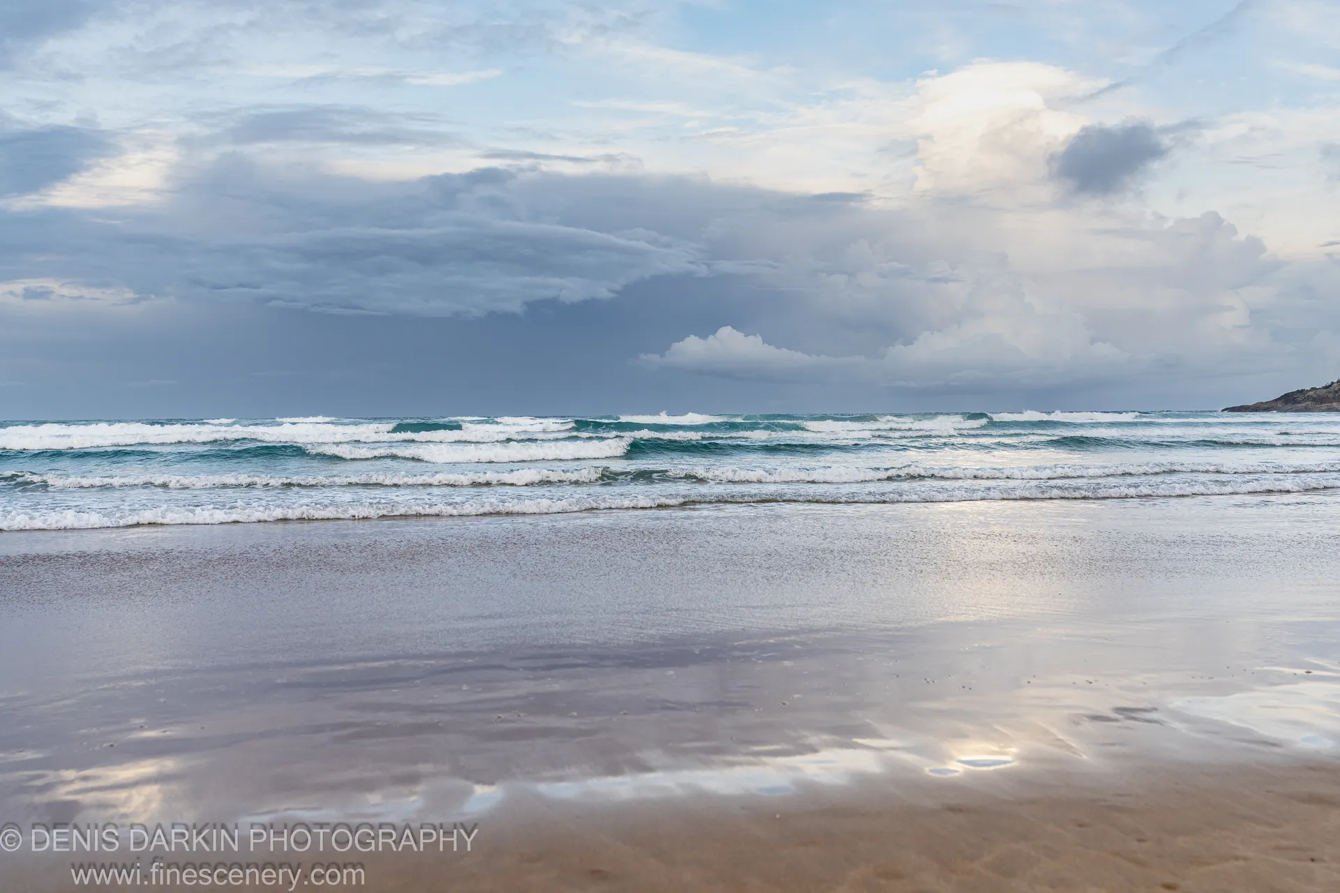 Expansive wet sand mirrors a layered sky above rolling surf on One Mile Beach, Port Stephens, in a late autumn afternoon.