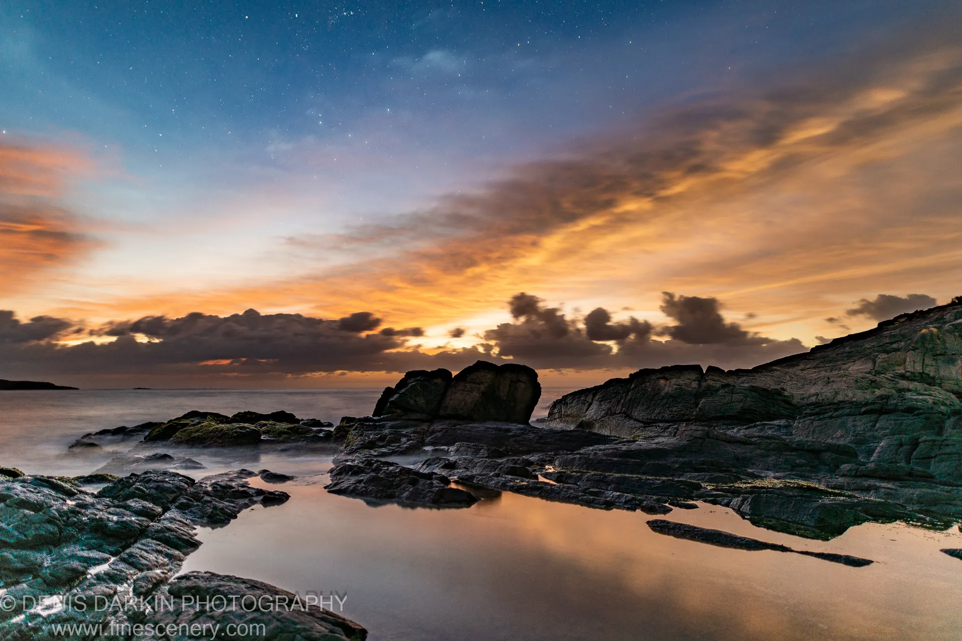 Smooth long-exposure waves on a rocky shore at pre-dawn near Nelson Bay, with moss-covered rock platforms and still tide pools in the foreground.