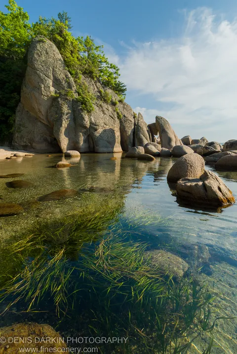 Clear coastal water reveals dense beds of submerged aquatic vegetation below granite cliffs at Langou Bay, Primorsky Krai.
