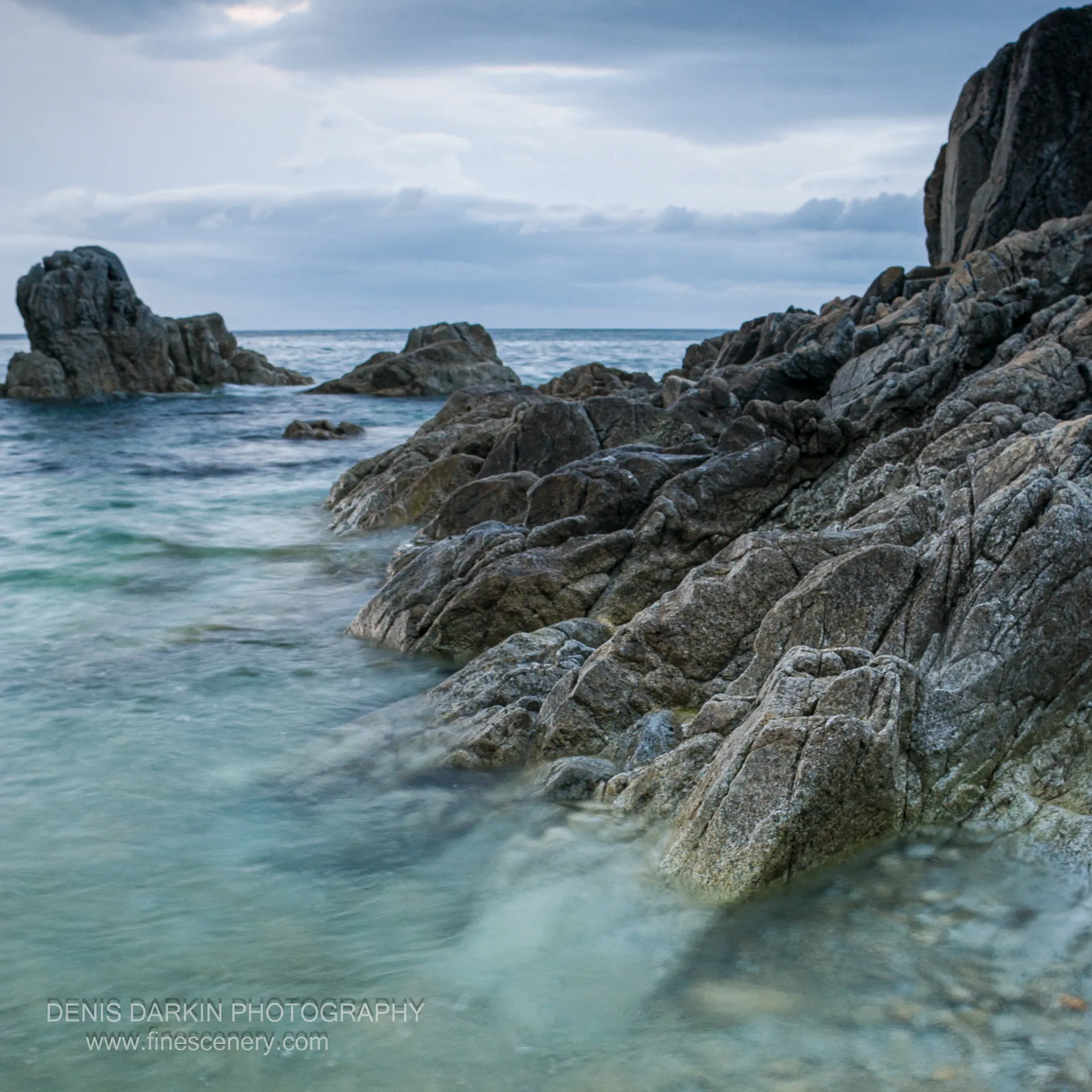 Jagged rock formations and distant sea stacks along the rocky shoreline of Vityaz Bay at dawn, early autumn 2006.