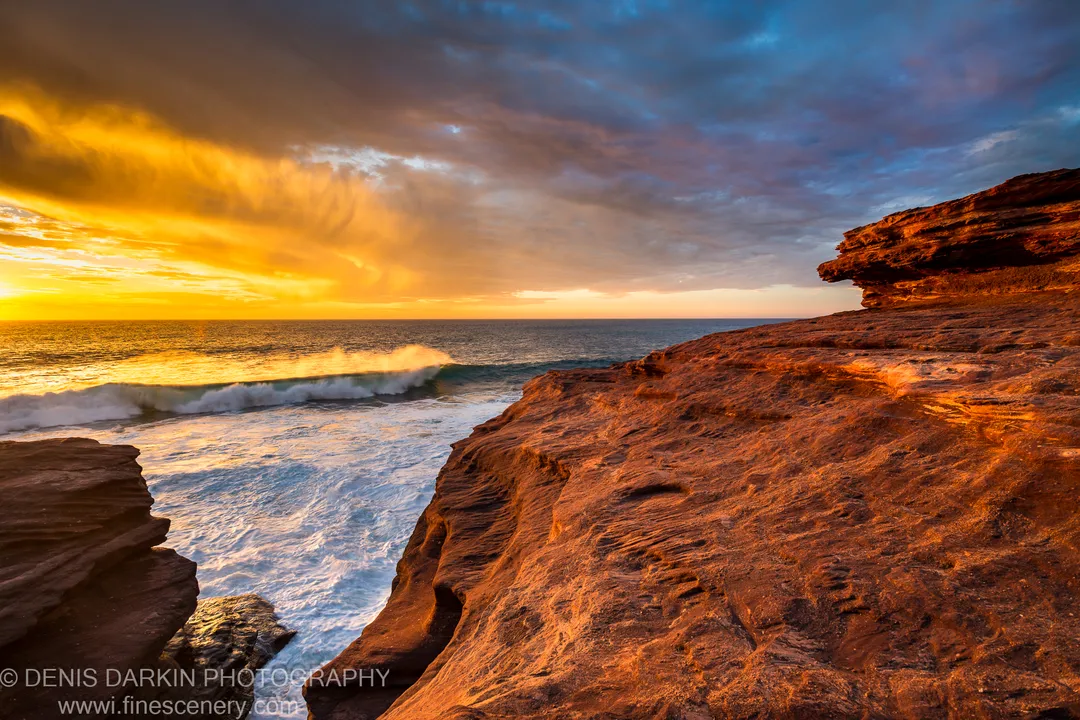 White sea foam fills the gap between two sandstone outcrops at Kalbarri as waves break during a clearing late-autumn storm.